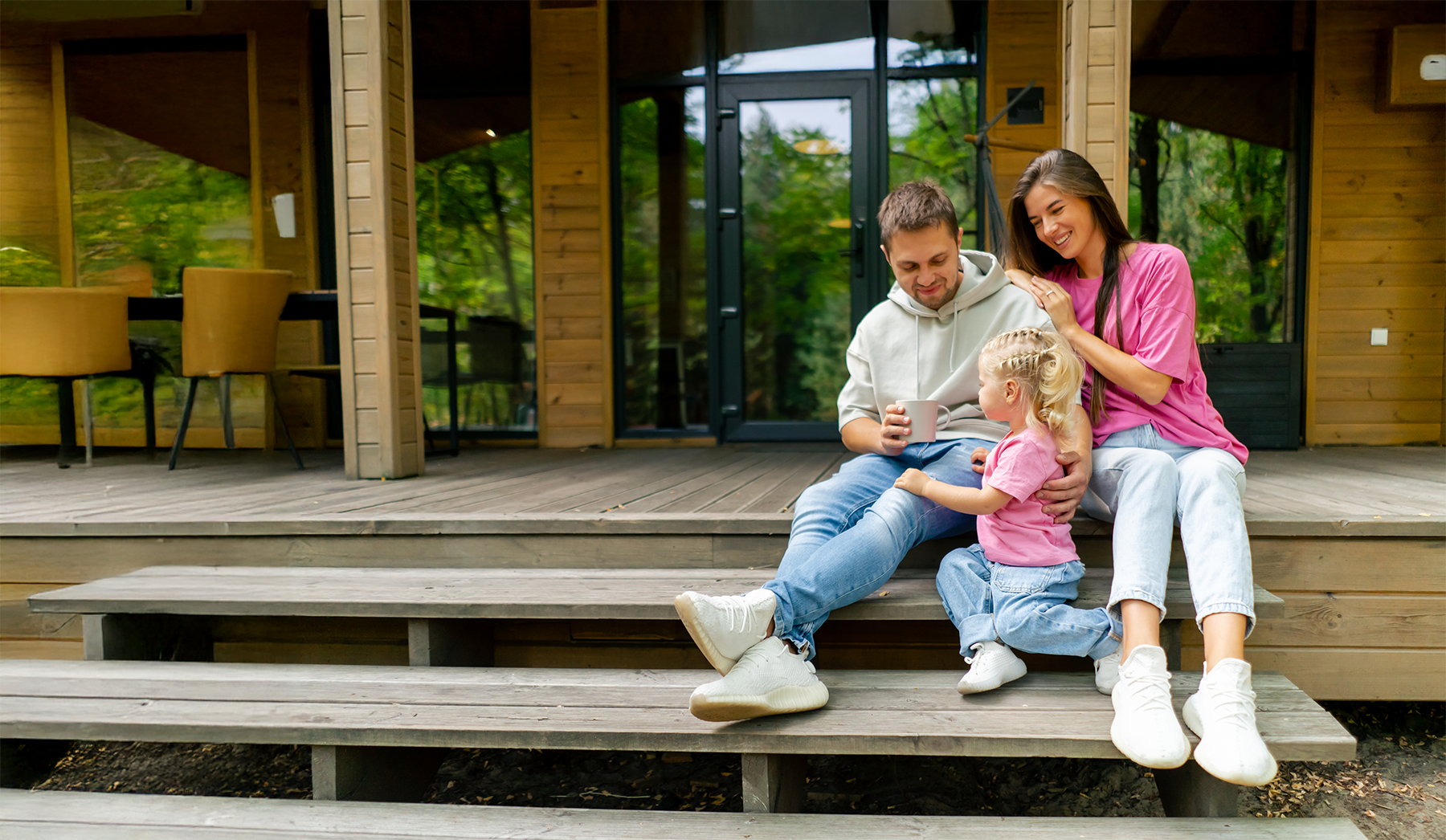 Family sitting on porch steps in front of a home